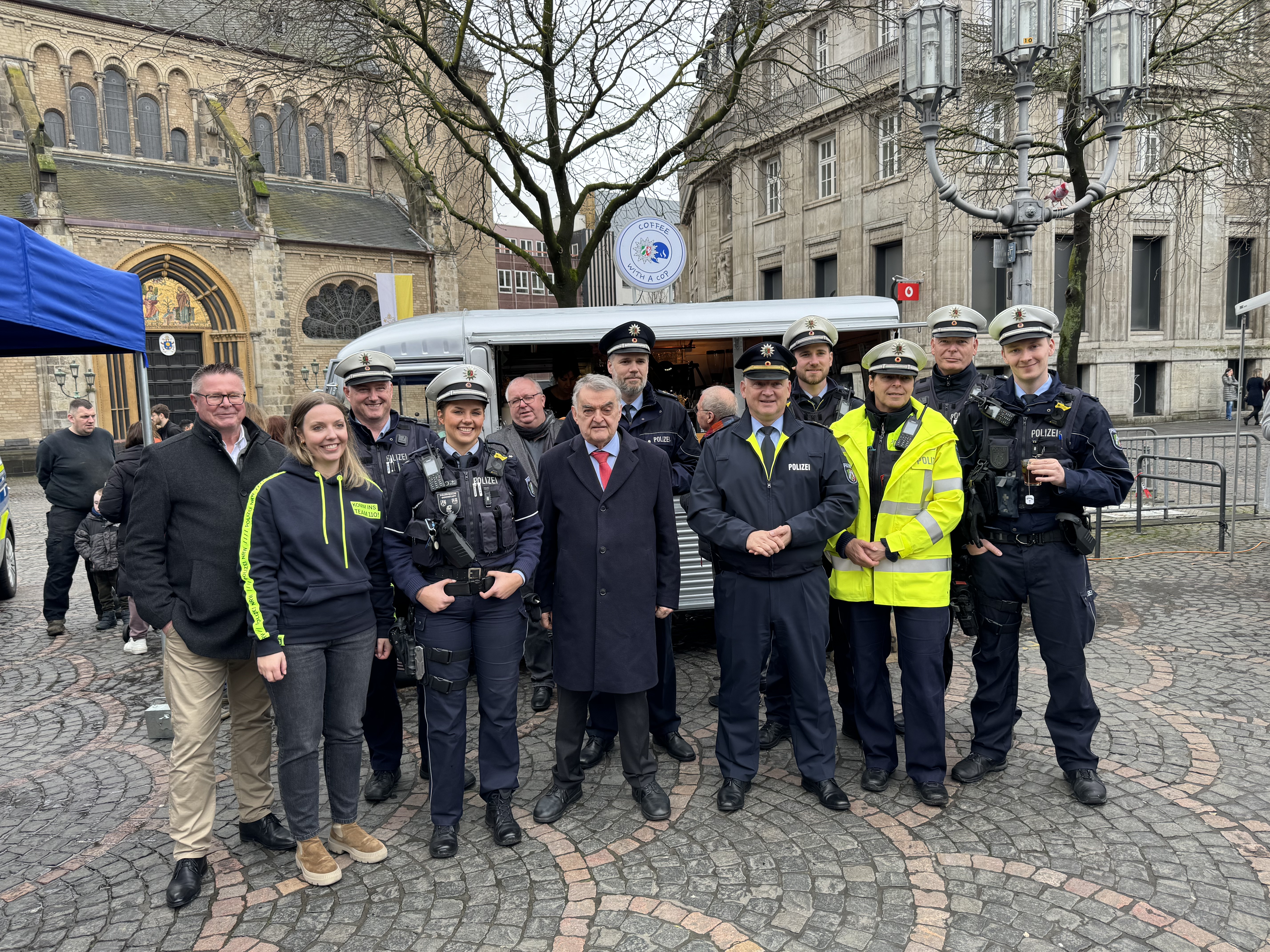 Viele Polizisten stehen vor dem Infostand der Polizei Bonn. Dazwischen Innenminister Herbert Reul und Polizeipräsident Frank Hoever.
