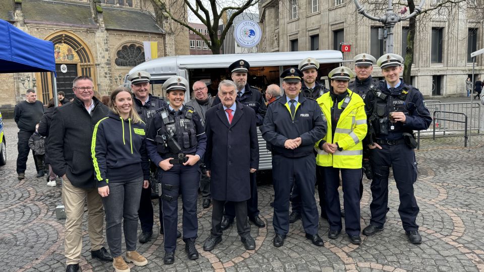 Viele Polizisten stehen vor dem Infostand der Polizei Bonn. Dazwischen Innenminister Herbert Reul und Polizeipräsident Frank Hoever.